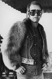 British Singer Elton John In Hollywood Wearing A Fur Jacket Over Dungarees And Large Sunglasses With His Initials Picked O Elton John Glasses Elton John Singer
