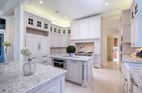 The white painted kitchen cabinets with glass doors and the oak island stained gray with carrera marble countertops combine to make it a blend of traditional elements and contemporary color. White Marble Kitchen Ideas Beautiful Designs Designing Idea