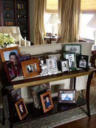 Arranging frames over a console is an easy way to draw attention to a wall by bringing some texture and layering to a room. How To Arrange Family Pictures On A Table 5 Ways For Stylish Room Home Improvement Day