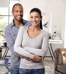 Happy Young Interracial Loving Couple Hugging And Smiling At Home, Looking  At Camera. Stock Photo, Picture And Royalty Free Image. Image 37393849.