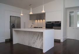 Sloped ceilings create a really intimate feeling. Outstanding Auckland White Back Splash Contemporary Kitchen Baseboards Sloped Ceiling Stainless Steel Appliances Kitchen Lighting Island Under Cabinet Waterfall