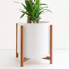 The softly colored flower pot is textured for additional interest. Peach Pebble 15 In White Ceramic Cylinder Planter With Medium Wood Stand 10 In 12 In Or 15 In Pl Ss Rb 03 28 15 The Home Depot