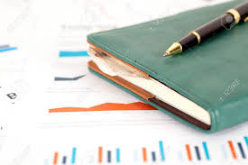 Notebook And Pen On Financial Chart