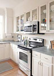 Reclaimed wooden cabinets match the cool, modern look of the gray concrete kitchen countertop, while the stone tile backsplash and open shelves add mountain style to the kitchen. Stylish Backsplash Pairings Better Homes Gardens