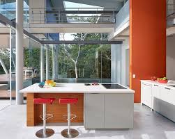 This Small And Modern Kitchen Has Minimal Cabinets With The Island Home To The Oven And Cooktop A Bright Oran Curved Kitchen Island Home Houses In Costa Rica
