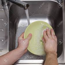 man washing dishes without gloves stock