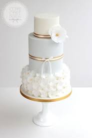 Wafer paper flowers are a popular form of cake decoration choice among bakers. Pale Blue And Gold Wedding Cake With Wafer Paper Flowers Cake Gold Wedding Cake Wedding Cakes
