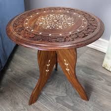 A coffee table is many things: Natural Geo Handcarved Round Rosewood Decorative Accent Table Overstock 31598703