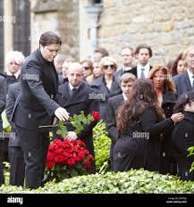 John Gibb (left), son of Robin Gibb, throws a rose onto the coffin at the  funeral of the Bee Gee singer in Thame Stock Photo