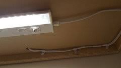 Attach the lights under the cabinets, string cable under the cabinet, and staple the cable in place using cable staples. Hiding Under Cabinet Light Wire