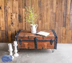 A rugged leather or wood steamer trunk with a lace table runner and crystal vase of flowers complement each other rather than clashing. Steamer Trunk Coffee Table Roots Wings Furniture Llc