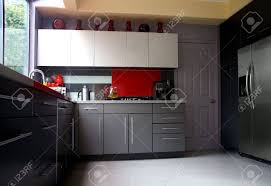 Creative homeowners who want to highlight a bold color in their new kitchen project will adore these red backsplash ideas. A Modern Kitchen With Gray Cabinets And Glass Backsplash Stock Photo Picture And Royalty Free Image Image 3829840