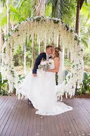 Circle Of Love White Hanging Wisteria Arbour A Beautiful Couple On Their Special Flower Wall Wedding Ceremony Backdrop Wisteria Wedding Flower Wall Wedding