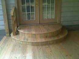 View of an outdoor door wooden stairs with a wooden pergola above the landing on a sunny day. Back Door Curved Landing Steps Idea Patio Stairs Porch Steps Patio Steps