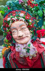 Bournemouth, Dorset, UK. 20th December 2018. The ancient wayfarer puppet "Winter  Rose" adorned with festive flowers and foliage, holly, ivy and mistletoe  symbolising ancient traditional Christmas celebrations, does a walkabout  through Bournemouth ...
