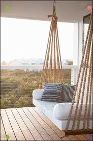 Chic Covered Second Floor Balcony Is Fitted With A Rope Swing Bed Adorned With Plush White Cushions And Blue Striped Pillow Home Decor Porch Swing Swing Design