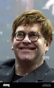 Il musicista Sir Elton John di fronte all'ingresso del negozio Selfridges,  Oxford Street, Londra, dove l'immagine della stella fa parte di quella che  sarà la fotografia più grande del mondo, che si