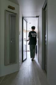 斜めの壁が自然なリビングへの導入となっている リビング入り口のガラス建具は sanwa company のもの クールビューティ 家具のプロジェクト リビング