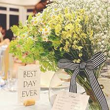 ゲストテーブルの装花はグリーンとイエローとホワイトで 予想外に大きかったという花束 は フローリストさんが 大サービス してくれたそう ご新婦さまご指定のストライプのリボンでまとめられているのも とってもおしゃれ センスが光ります 結婚式 グリーン