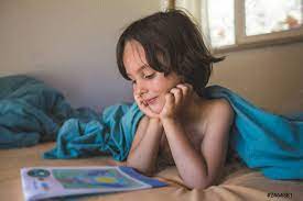 Der Junge Liegt Im Bett Und Liest Ein Buch Foto Vorratig Crushpixel