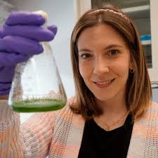 Carolina Trenado-Yuste, a postdoctoral fellow in the lab of Sujit Datta,  holds up a culture of cyanobacteria, also known as blue-green algae. The  vibrant green color originates from chlorophyll. Cyanobacteria have the