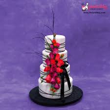 Four tiered white wedding cake with green ribbons and flowers. Vertical Flower Cascade Wedding Cake With Crossover Ribbons Yeners Way