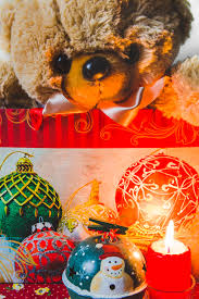 Free Photo Teddybear In Shopping Bag With Decorative Christmas Ornaments And Lit Candle