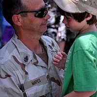 Lt. Wade Horton, Engineering Officer for the 30th Naval Construction  Regiment (NCR) 30 Gold Team, watches his son walk for the first time during  the unit's homecoming.