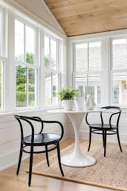 Black Bistro Chairs Sit On A Bound Sisal Rug At A White Saarinen Table Bistro Chairs Sunroom Decorating Home