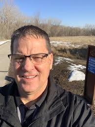 Tim Doyle shares his enthusiasm of all things Dodge! Standing in front of  the downtown Prairie River Trail Central Avenue Trail Head. Tim Doyle is  involved with the Annual Prairie River Trail