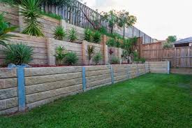 The narrow cinder blocks are placed in a two layer wall that separates the pebbled path from the flower garden. 95 Stunning Retaining Wall Ideas