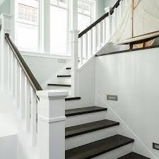 Staining not only makes a banister look like new, but it also adds a layer of protection to the wood underneath the finish. White Spindles With Dark Brown Banister Design Ideas