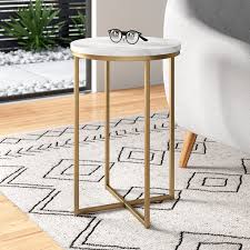 Founded atop an open metal base. Mistana Wasser End Table