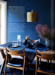 This contemporary dining room features an accent wall filled with a colorful collection of blue plates. Midnight Express Colour Your Home In Indigo Interiors By Color