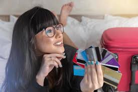 bella donna che tiene una mano più carte di credito sul letto in hotel.  soldi di plastica. viaggiare. concetto di donna ricca in viaggio. 7717048  Stock Photo su Vecteezy