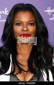 In this July 30, 2018, photograph, Brookville Gardens librarian Shanice  Davis helps her son Josiah Davis, 3, pick out a book to read at home from  the housing complex's library, in Starkville,
