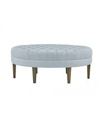 Light Blue Fabric Oval Coffee Table Ottoman Bench A casual color palette that includes a cream colored couch, blue and brown pillows, and a blue ottoman coffee table.