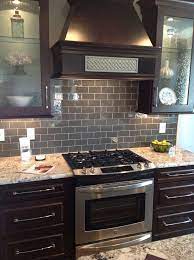 Ice Gray Glass Subway Tile Backsplash With Dark Brown Cabinets And Sta Ice Gray G Trendy Kitchen Backsplash Backsplash With Dark Cabinets Kitchen Remodel
