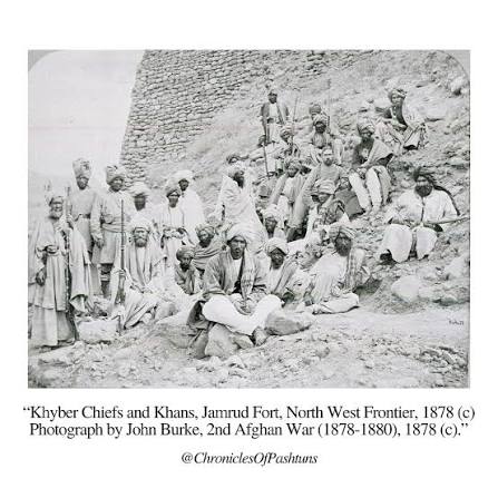 Photograph of Sir Pierre Louis Napoleon Cavagnari (1841-79) meeting with Afghan leaders in a garden in Jalalabad. The large group of Afghan leaders are arranged in a semi-circle around a series of