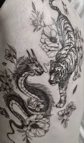 Only the eyes of the tiger and the bridge of its nose are depicted in this tiger tattoo. My Baby Dragon And Tiger Yin Yang Tattoo Dragon Tiger Tattoo Tiger Tattoo Thigh