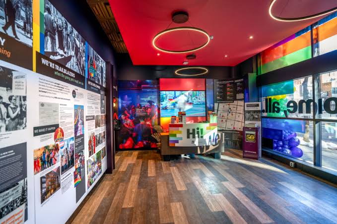 Interior of the Philly Pride Visitor Center with history panels and a visitor desk