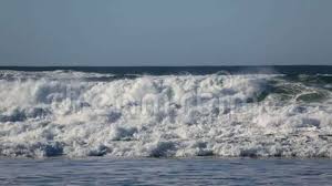 Crashing Waves Over Against Blue Sky Along Pacific Ocean In Cannon Beach Oregon