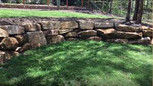 Compare the pros and cons, style, and durability characteristics of seven retaining wall building materials including concrete block, stone veneer, poured concrete, brick, wood, gabion walls, and dry stone walls. Landscaping Rock Walls Are Beautiful Qc Landscaping