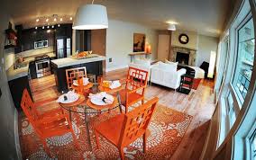 This contemporary dining room features an accent wall filled with a colorful collection of blue plates. How To Use Orange Colors Creatively And Add Interest To Modern Dining Room Decorating