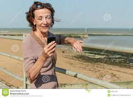 Reife Frau, Die Auf Dem Strand Simst Stockbild - Bild von telefon, haar:  54847309