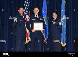Technical Sergeant Craig Eveland receives the Distinguished Graduate for  NCO Academy class 18-6 from Chief Master Sgt. Darin Mauzy, Command Chief of  the 158th Fighter Wing, and Senior Master Sgt. Ramey Stokes,