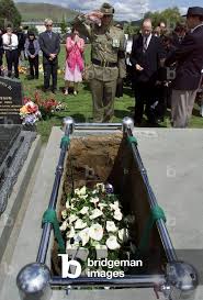 Image of TROY RODGERS SALUTES ABOVE HARRY BURTON'S COFFIN AT GRAVESITE IN  HOBART,