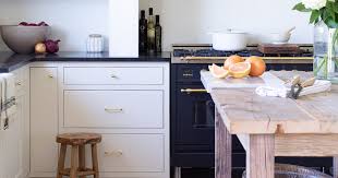 That dramatic design continues into the kitchen, where black cabinets create a cool visual contrast to the white walls. White Kitchen Cabinets With Black Countertops Are The Next Big Reno Trend