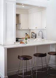Incorporating a peninsula with corian counter into the design of this small contemporary kitchen adds more work space and functions as an informal dining area all at the same time. Small Kitchen Peninsula Design Ideas