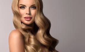 Young gorgeous lady with wavy, dense hair, and charming look. Blonde Girl With Long And Volume Shiny Wavy Hair Beautiful Woman Model With Curly Hairstyle Mooi Hair Extensions